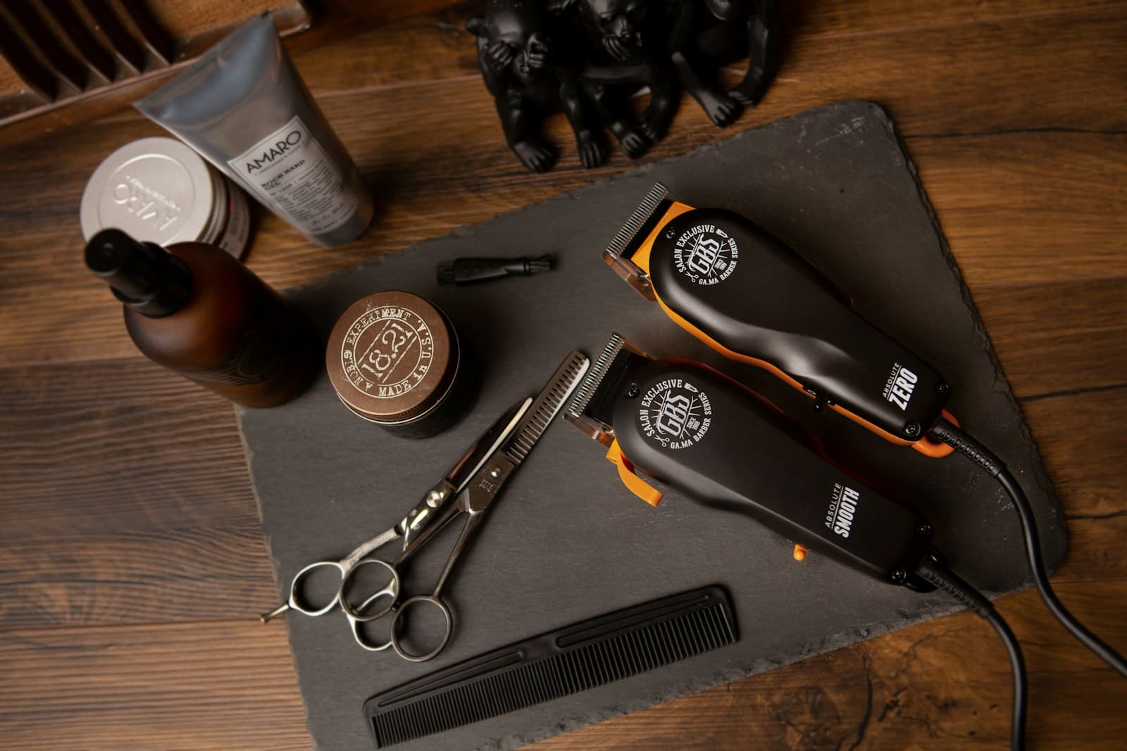 A barber's shears, clippers, and combs arranged on a workstation