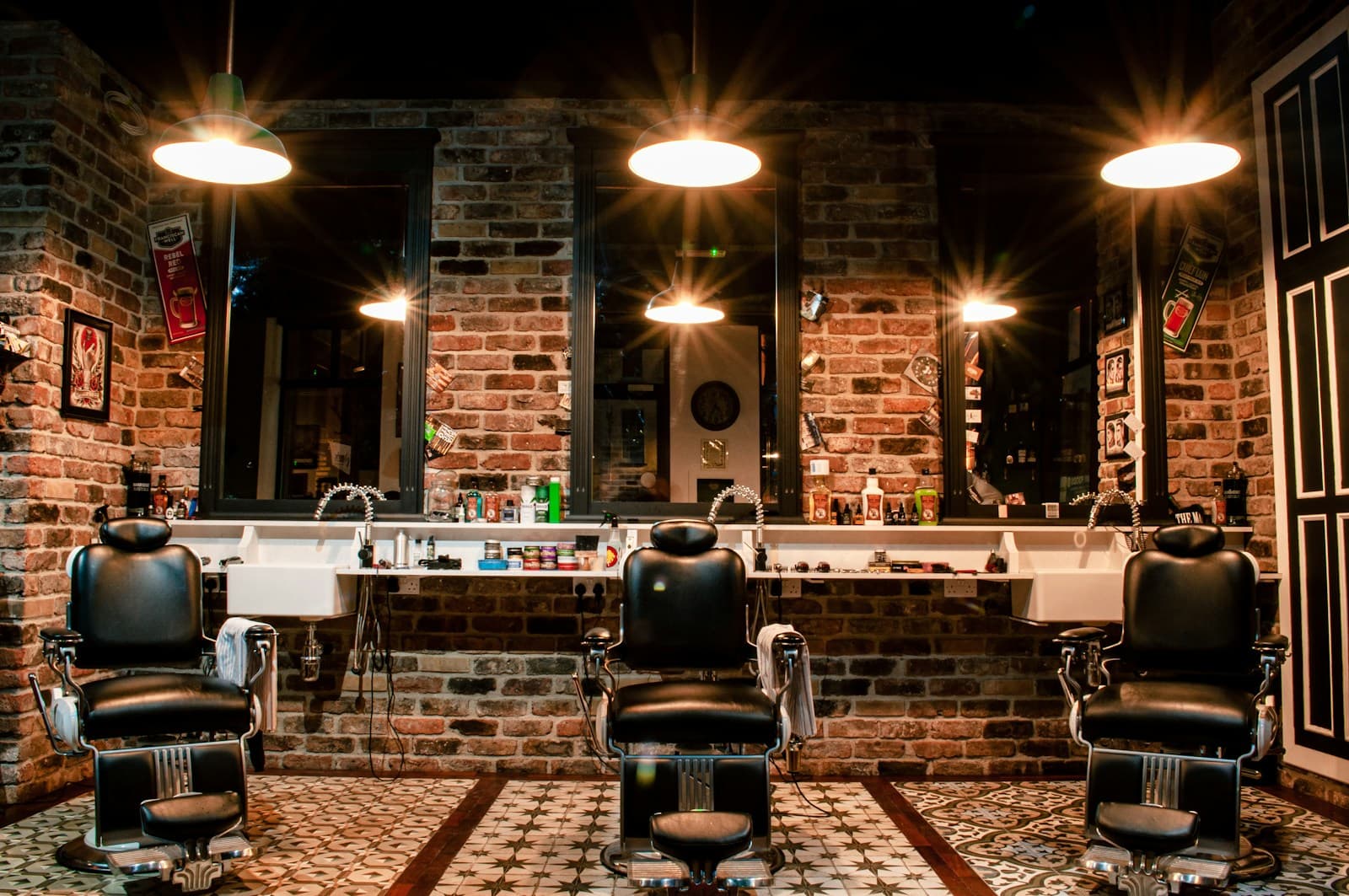 A barber working at his station in a warm, dimly lit shop